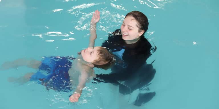student learning to tread water with a swim instructor