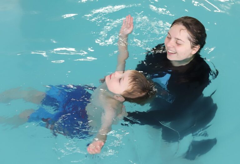 student learning to tread water with a swim instructor