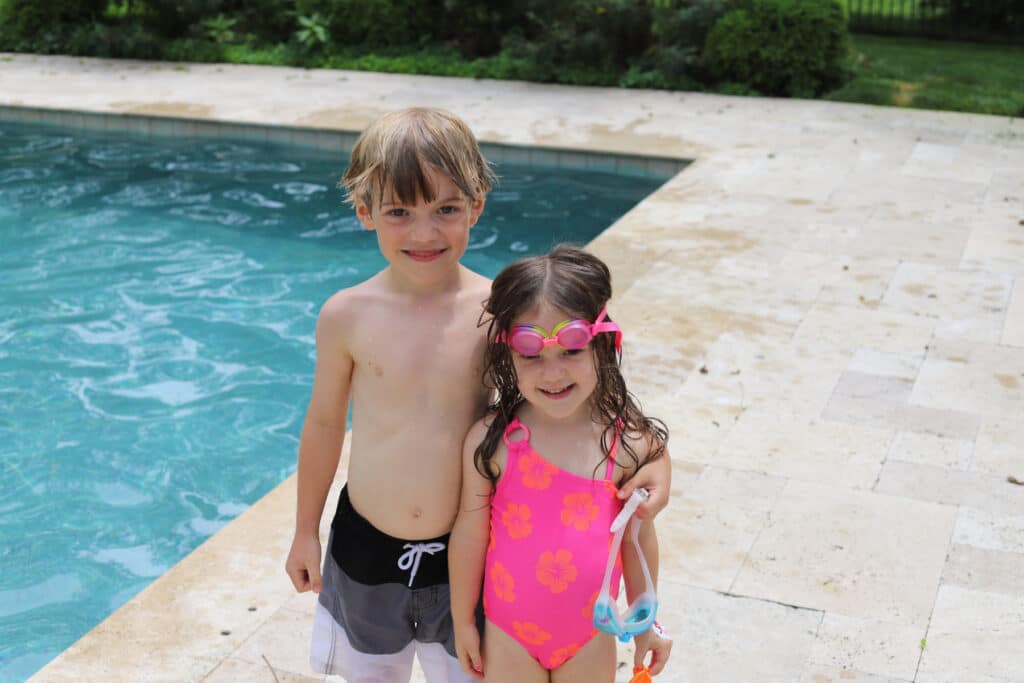 two kids overcame their fears during swim lessons and pose for a picture